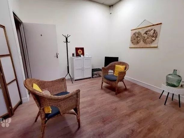 Deux fauteuils en osier et des coussins jaunes dans le cabinet de Montmirail